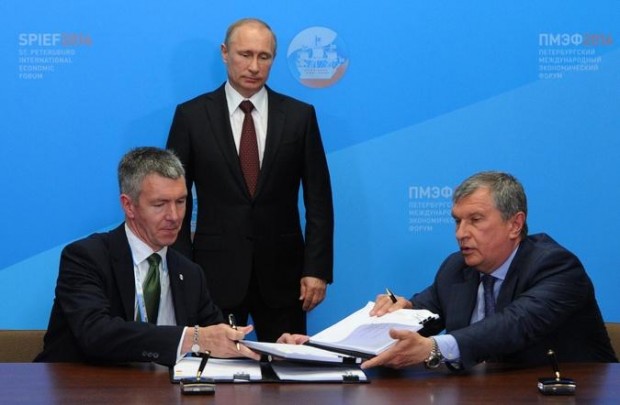 Putin, center, attends a signing ceremony of documents on the results of his meeting with heads of the leading energy companies at the economic forum in St. Petersburg, Russia, 24 May 2014, as President of BP Russia, David Campbell, left, and CEO of state-controlled Russian oil company Rosneft Igor Sechin sign documents. Photo by Mikhail Klimentyev/Presidential Press Service