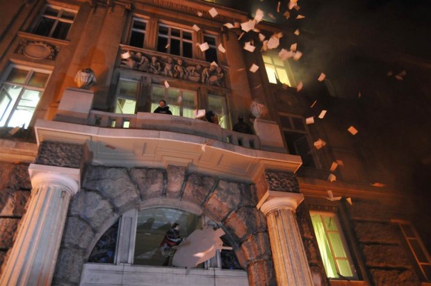 Ukrainian protesters throw out papers from prosecutor's headquarters in Lviv early on Feb. 19.