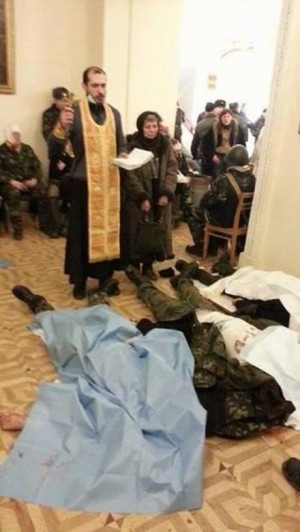 A priest gives last rites to three demonstrators shot to death today by police. | Kviv Post