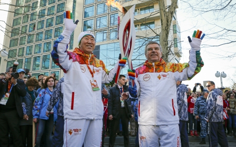 International Olympic Committee president Thomas Bach hands over the Olympic torch to UN Secretary General Ban Ki-moon as the torch relay arrives in Sochi on Thursday for the Winter Olympics. Photo: AP