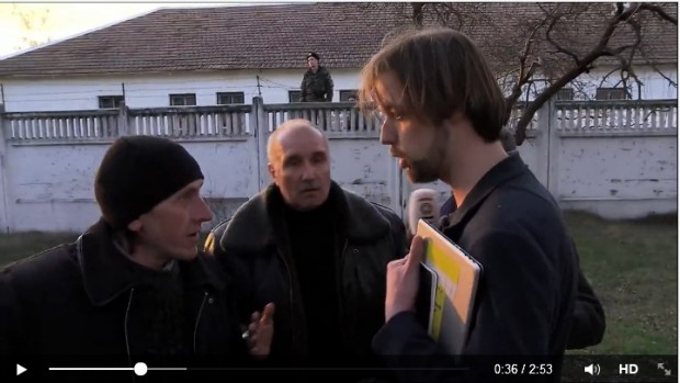 Oleg Koens faces off against unidentified "self-defense volunteers" at an army base in the Crimea.