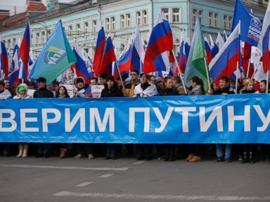Banner: "We Trust Putin". Photo by AP