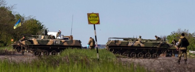 Ukrainian soldiers walk near armoured personnel carriers at a checkpoint in near the town of Slaviansk, in eastern Ukraine