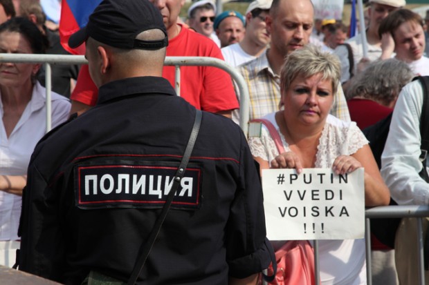 Moscow police guard demonstrator with sign, "Putin - Bring in Forces!" 2 August 2014. Photo by Elena Gorbacheva.